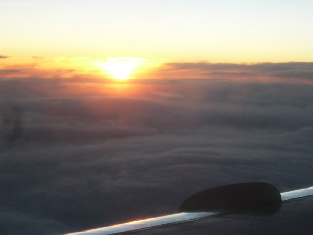 sun setting beneath clouds