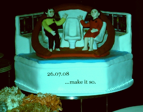 middle layer of star trek wedding cake 
featuring the bride and groom as starfleet
personnel on the bridge.